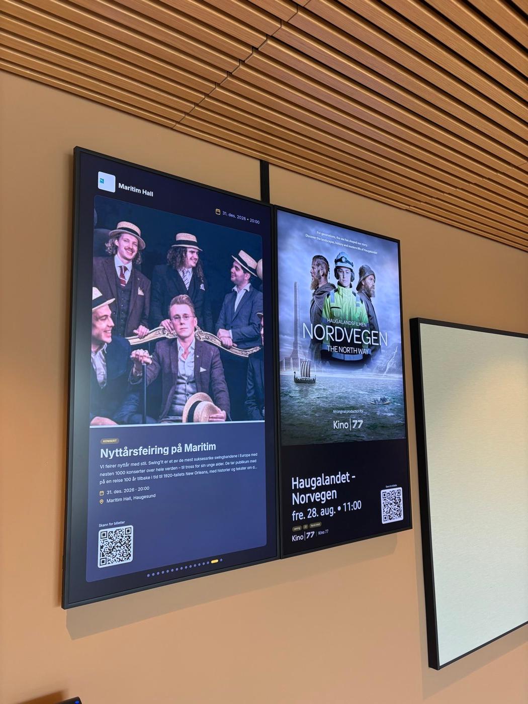 To skjermer side om side i en foajé: konsert på Maritim Hall og film på Kino 77